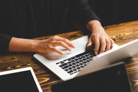 A person is operating a laptop.