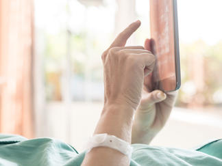 Patient im Krankenzimmer bedient ein Tablet